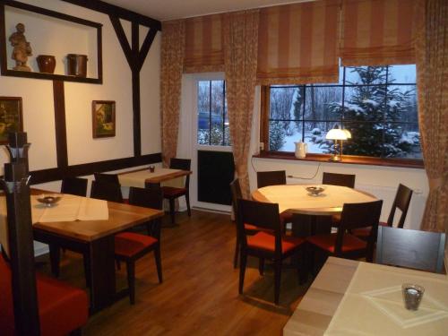 a restaurant with tables and chairs and a window at Hotel Grüner Jäger in Travemünde
