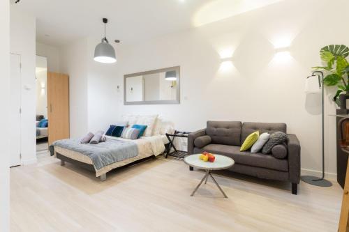 un salon avec un canapé et une table dans l'établissement Jardin Secret Studio Terrasse Panier Vieux-Port Marseille, à Marseille