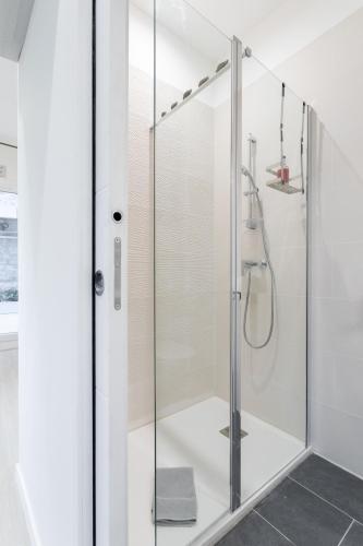 une douche avec une porte vitrée dans une salle de bain dans l'établissement Jardin Secret Studio Terrasse Panier Vieux-Port Marseille, à Marseille