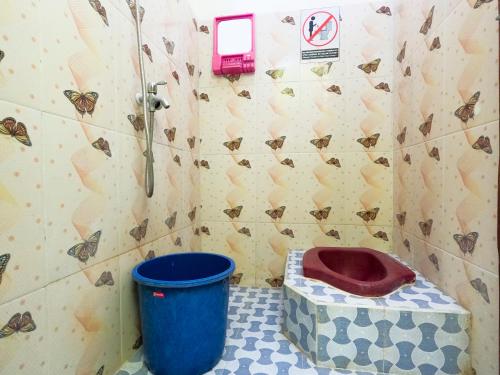 a bathroom with a toilet and a blue bucket at Homestay Kampung Inggris SYARIAH in Pare