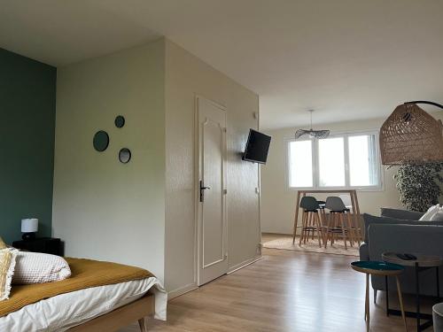 une chambre avec un lit et un salon dans l'établissement le chat perché, à Honfleur