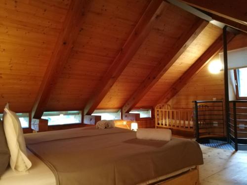 a large bed in a room with wooden ceilings at RUSTICO CONCEPRIO & SAUNA in Corzoneso