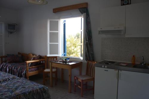 eine kleine Küche mit einem Tisch und einem Fenster in der Unterkunft Mavromatis Studios in Naxos Chora