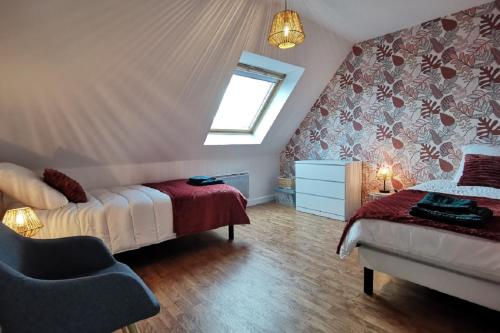 a bedroom with two beds and a window and a chair at Maison Bretagne bord de mer in Guissény