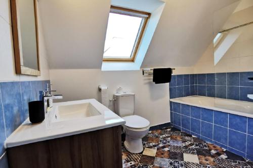 a bathroom with a sink and a toilet and a tub at Maison Bretagne bord de mer in Guissény