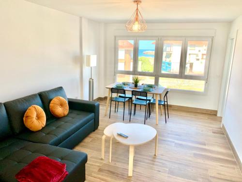 a living room with a couch and a table at Apartamento Arenal ATICO in Noja