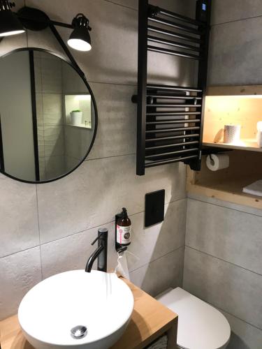 a bathroom with a white sink and a mirror at Au Vingtain - Appartement & Spa atypique in Brindas