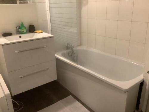 ein weißes Badezimmer mit einer Badewanne und einem Waschbecken in der Unterkunft L'Etoile in Nîmes
