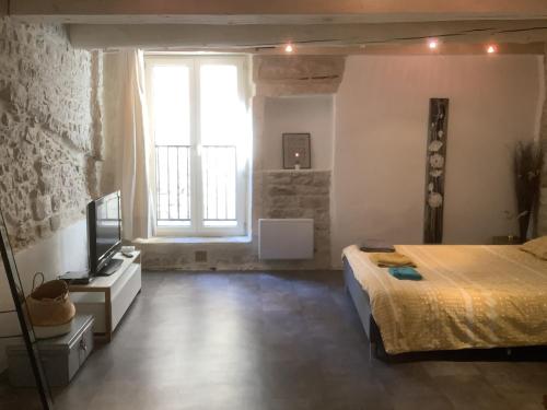 ein Schlafzimmer mit einem Bett und einem großen Fenster in der Unterkunft L'Etoile in Nîmes