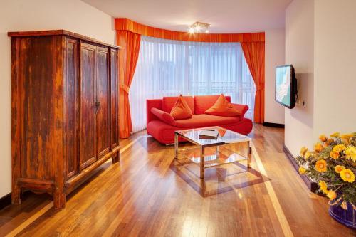 a living room with a red couch and a table at Alexander am Zoo in Frankfurt/Main