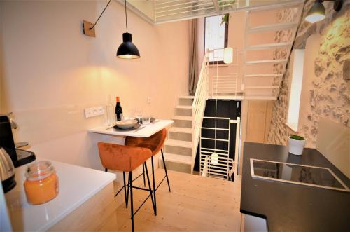 a small kitchen with a counter and a table in a room at Au Vingtain - Appartement & Spa atypique in Brindas