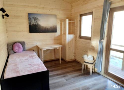 Habitación con cama y escritorio en una cabaña en Tiny-river, en Falaën