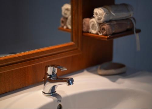 a bathroom sink with a faucet and a mirror at Jasmin Villa Nissaki in Nisakion