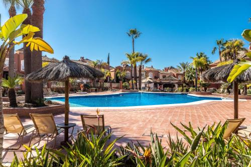 una piscina con sillas y sombrillas en Solvasari, en Marbella