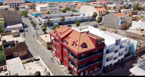 um edifício vermelho com um telhado vermelho numa cidade em Apartamento Coral em Santa Maria