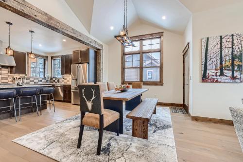a kitchen and living room with a wooden table and chairs at Deere Retreat Home: Hot Tub, Stylish in Overlook Athletic Club Heliport
