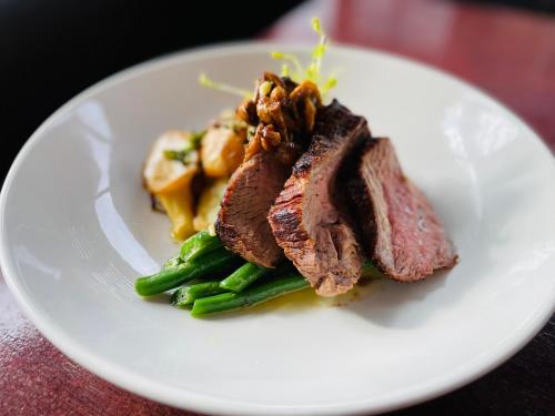 a white plate with a piece of meat and vegetables at Silken Thomas Accommodation in Kildare