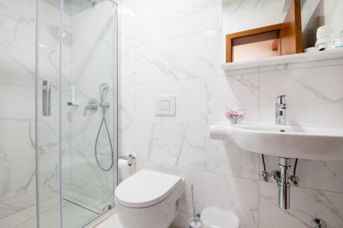 een badkamer met een douche, een toilet en een wastafel bij Hotel Villa Nova in Neum