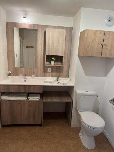 La salle de bains est pourvue de toilettes blanches et d'un lavabo. dans l'établissement Domitys - Résidence Services Seniors - Le Havre Nord, à Montivilliers