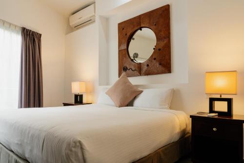 1 dormitorio con 1 cama grande y espejo en Almarea Vacation Condo, en Playa del Carmen