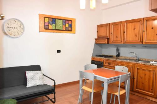 eine Küche mit einem Tisch und einer Uhr an der Wand in der Unterkunft Casa Lulù in Riva Ligure