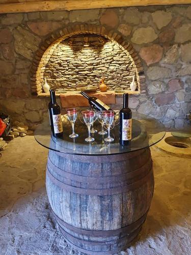 a wine barrel with three wine glasses and a fireplace at ART Chalet in Akhaltsikhe