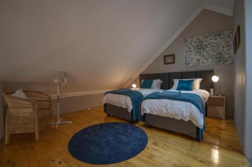 1 dormitorio con cama y alfombra azul en C'est La Vie, en Howick