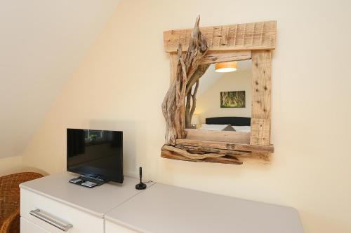 a mirror on a wall above a dresser with a television at The Ferns-Ideal base for exploring the Causeway Coast in Armoy