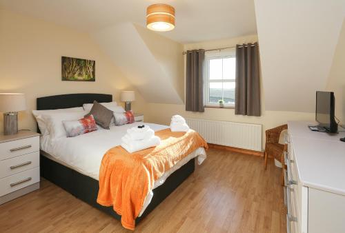 Un dormitorio con una cama con una manta naranja. en The Ferns-Ideal base for exploring the Causeway Coast en Armoy