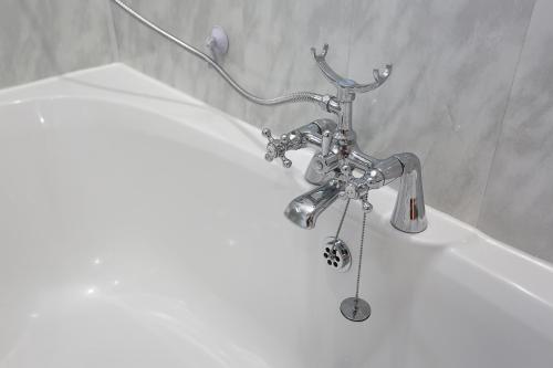 a bath tub with a sink and a faucet at The Ferns-Ideal base for exploring the Causeway Coast in Armoy