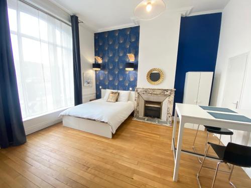 a living room with a bed and a fireplace at Résidence Adam à part in Valenciennes