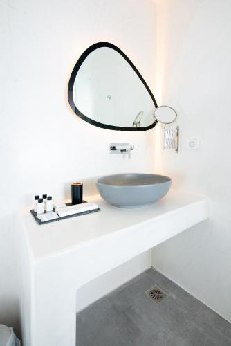 a bathroom with a bowl sink and a mirror at Caldera Cliff Illusion in Fira