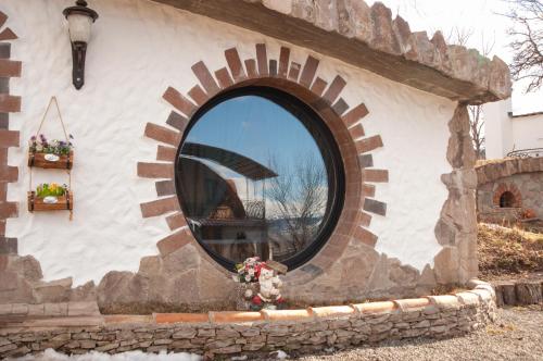 a circular window on a stone building with a mirror at ART Chalet in Akhaltsikhe