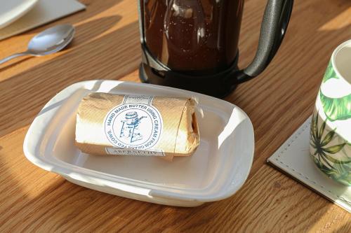 a white plate with a roll of paper on a table at The Ferns-Ideal base for exploring the Causeway Coast in Armoy