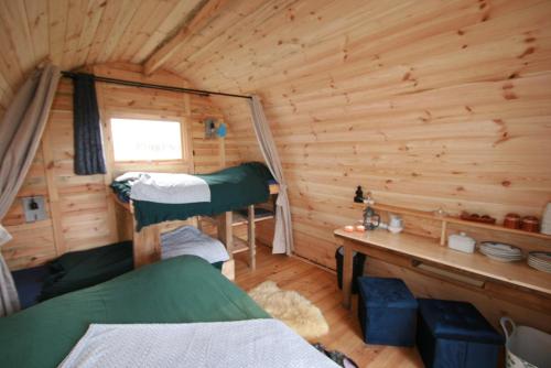 a room with two bunk beds in a log cabin at Cabane Les Pourettes in Feusines