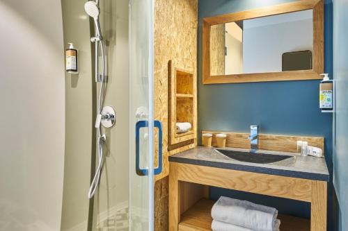 a bathroom with a sink and a shower at Ibis Budget Paris porte de la Chapelle - Aréna in Paris