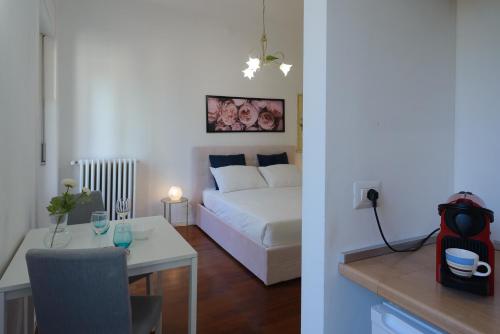 ミラノにあるMilanoverse Junior Apartmentのベッドルーム1室(白いベッド1台、テーブル、テーブルシックスシックス付)