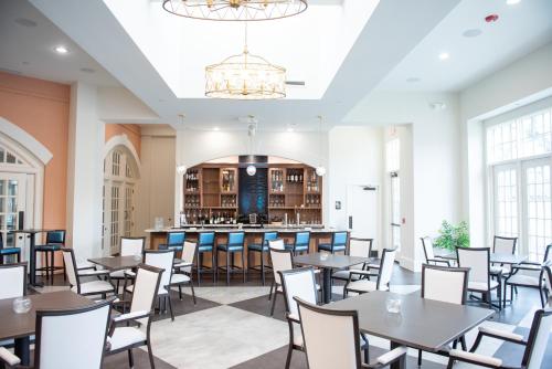 a dining room with tables and chairs and a bar at JH Adams Inn, Trademark Collection by Wyndham in High Point