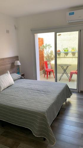 a bedroom with a bed and a patio with a table at Costanera Aparts in Villa María