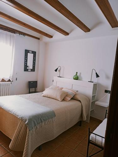 a white bedroom with a bed and a mirror at Casa la Era in Nogueruelas