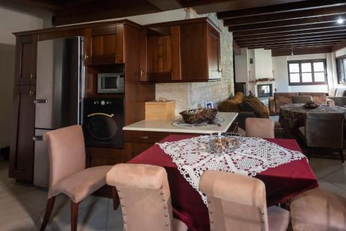 una cocina con una mesa con un mantel rojo. en Kourtis Family Mansion, en Karpenisi