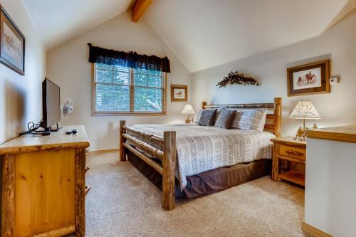 ein Schlafzimmer mit einem Holzbett und einem Fenster in der Unterkunft Corral at Breckenridge 207S Heron Condo a Spacious Great Location in Breckenridge