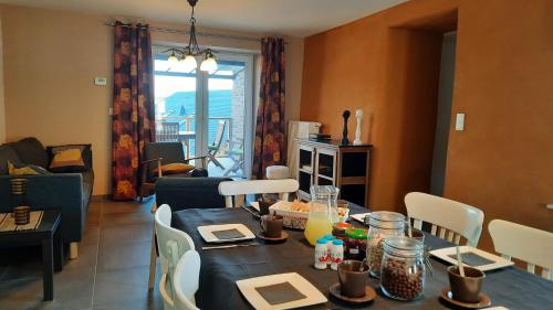 a living room with a table and a dining room at D'un coin à l'autre in Nadrin