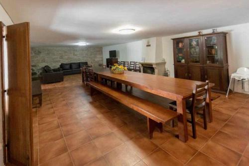 a living room with a wooden table and a couch at Casa do Pioledo (Camélias de Basto) in Lamelas