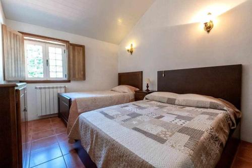 a bedroom with two beds and a window at Casa do Pioledo (Camélias de Basto) in Lamelas