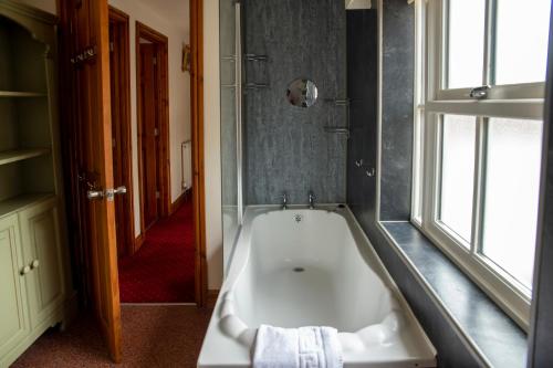 eine Badewanne im Bad mit Fenster in der Unterkunft The Knighton Apartment in Knighton