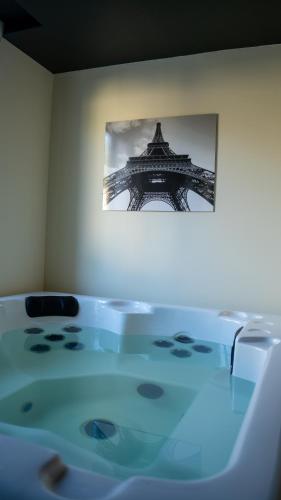 a table in a room with a picture of the eiffel tower at Magnifique Duplex avec Jaccuzi, Sauna et Cinema Room Privatif in Fontenoy