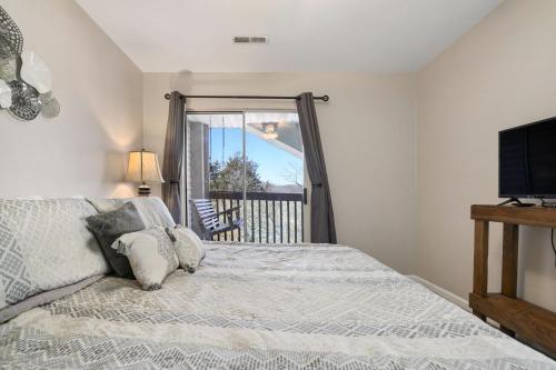 a bedroom with a bed and a tv and a window at Eagle Nest Resort Pristine Dream in Branson