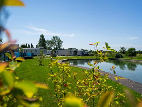 a pond in a park with houses in the background at Mill Rythe Coastal Village in South Hayling