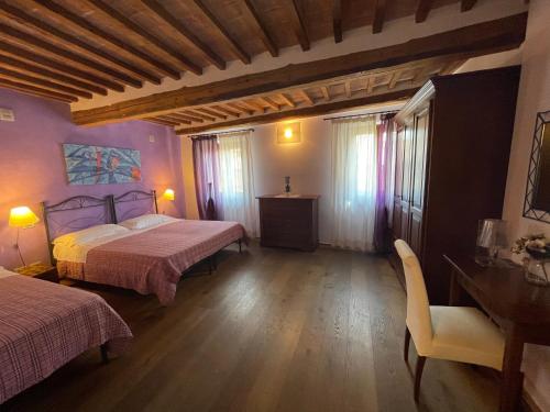 a bedroom with two beds and a table and chairs at Dimora Del Corso Di Montepulciano in Montepulciano